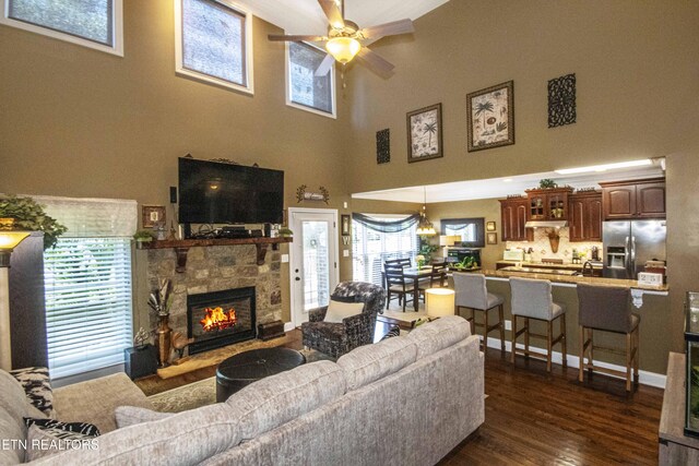 8507 Cloudbreak Ln Unit 4, Knoxville, TN 37938 - living room featuring a ceiling fan, dark wood-type flooring, a stone fireplace, and a towering ceiling