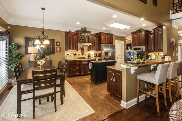 8507 Cloudbreak Ln Unit 4, Knoxville, TN 37938 - kitchen with stainless steel appliances, a kitchen island, ornamental molding, tasteful backsplash, and a chandelier