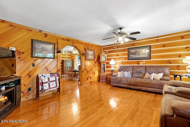 1821 S Nopone Valley Rd, Decatur, TN 37322 - living area featuring ceiling fan, a textured ceiling, light wood-style floors, wooden walls, and arched walkways