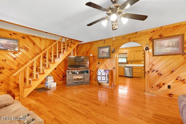 1821 S Nopone Valley Rd, Decatur, TN 37322 - living room featuring wood walls, stairway, light wood-style floors, and a ceiling fan