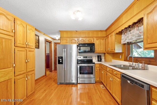 1821 S Nopone Valley Rd, Decatur, TN 37322 - kitchen with stainless steel appliances, ornamental molding, light countertops, light wood-style flooring, and a textured ceiling
