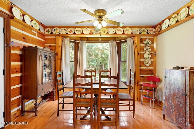1821 S Nopone Valley Rd, Decatur, TN 37322 - dining area with a textured ceiling, ceiling fan, light wood-style floors, and wood walls