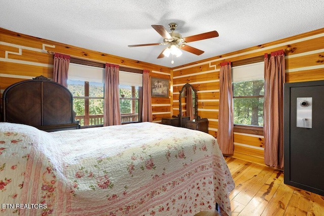 1821 S Nopone Valley Rd, Decatur, TN 37322 - bedroom featuring light wood-style flooring, wood walls, a textured ceiling, and ceiling fan