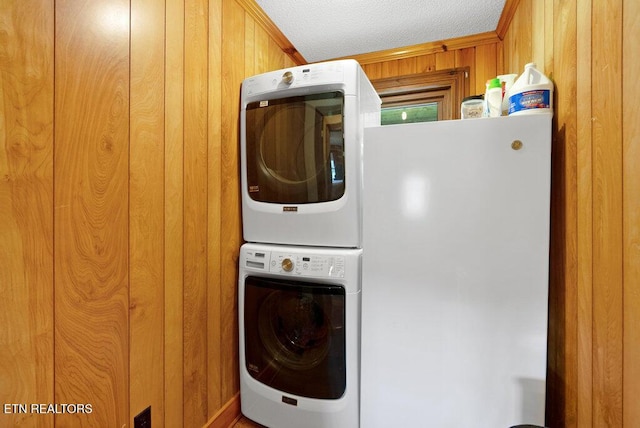 1821 S Nopone Valley Rd, Decatur, TN 37322 - laundry room featuring stacked washer / drying machine, wood walls, and a textured ceiling