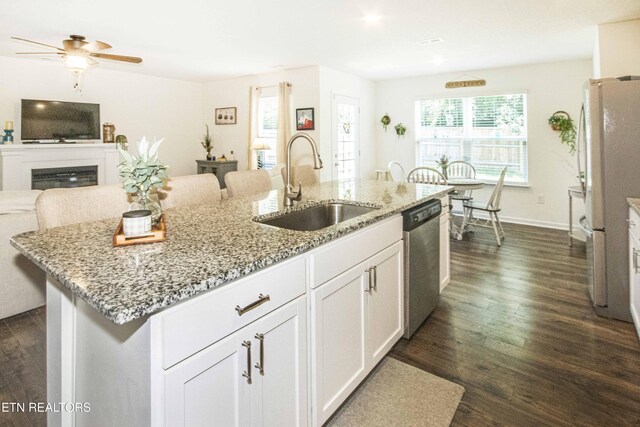 7408 Game Bird St, Corryton, TN 37721 - kitchen featuring stainless steel dishwasher, dark wood-style flooring, a center island with sink, open floor plan, and white cabinets