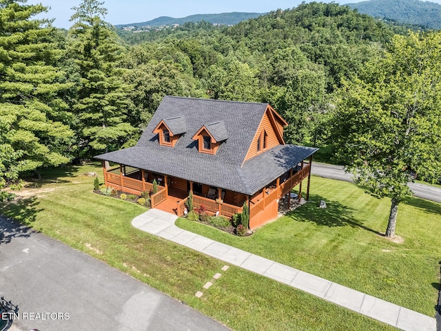 2028 Piney Overlook Ln, Sevierville, TN 37862 - view of front facade featuring covered porch, a wooded view, a front lawn, and roof with shingles