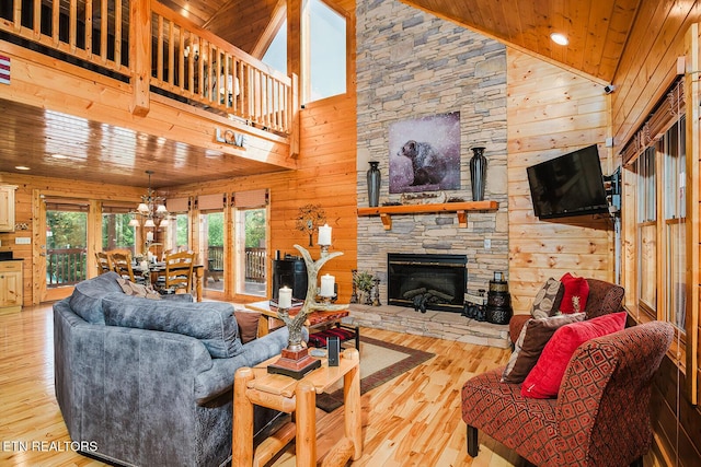 2028 Piney Overlook Ln, Sevierville, TN 37862 - living room featuring wood walls, high vaulted ceiling, wood finished floors, a stone fireplace, and wooden ceiling