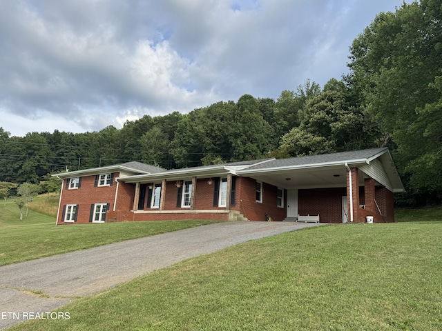 115 Red Oak Ln, New Tazewell, TN 37825 - tri-level home featuring driveway, brick siding, a front lawn, an attached carport, and a view of trees