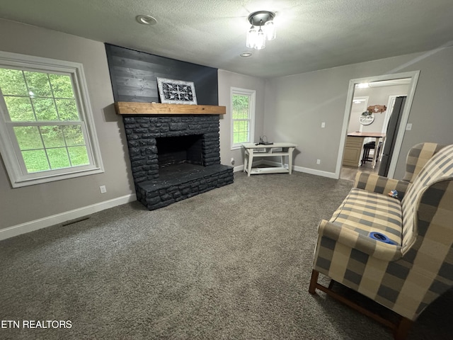 115 Red Oak Ln, New Tazewell, TN 37825 - living area featuring a textured ceiling, dark colored carpet, and a stone fireplace