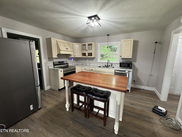 115 Red Oak Ln, New Tazewell, TN 37825 - kitchen with stainless steel appliances, wooden counters, dark wood-style floors, a breakfast bar area, and glass insert cabinets
