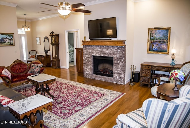 520 Wimberly Rd, Crossville, TN 38558 - living room featuring wood finished floors, crown molding, a ceiling fan, a fireplace, and a chandelier