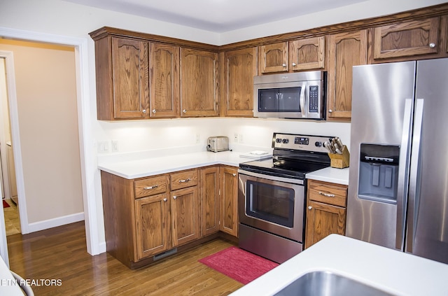 520 Wimberly Rd, Crossville, TN 38558 - kitchen with stainless steel appliances, dark wood-style flooring, light countertops, and brown cabinets