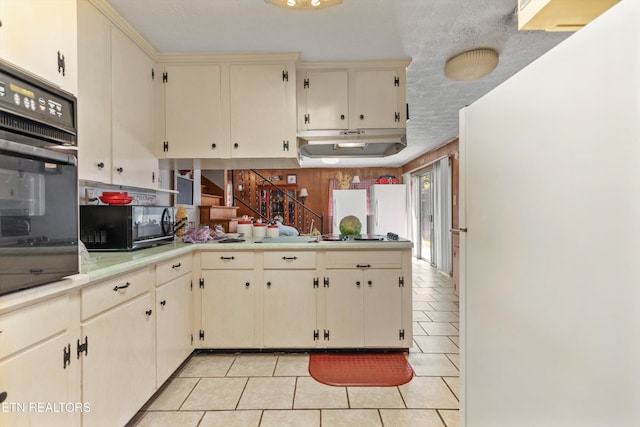 1175 Cardnal Cv, Rutledge, TN 37861 - kitchen with cream cabinets, black appliances, light tile patterned floors, light countertops, and a peninsula
