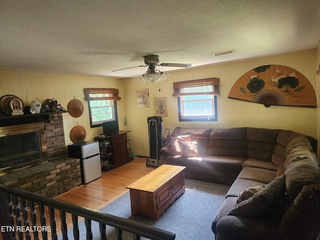 5412 E Lamar Alex Pkwy, Walland, TN 37886 - living area with plenty of natural light, a textured ceiling, a ceiling fan, a brick fireplace, and wood walls