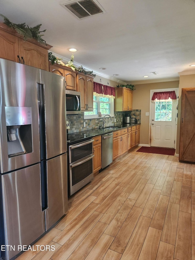 5412 E Lamar Alex Pkwy, Walland, TN 37886 - kitchen featuring appliances with stainless steel finishes, dark countertops, light wood-style floors, ornamental molding, and plenty of natural light