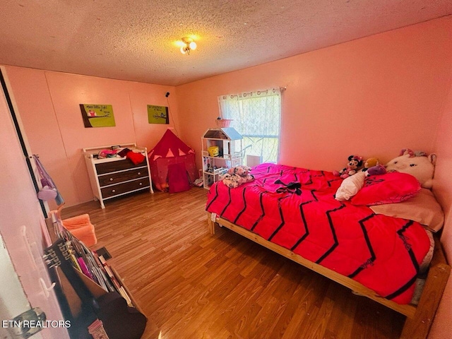 181 Claude Hargis Ln, Crawford, TN 38554 - bedroom with wood finished floors and a textured ceiling