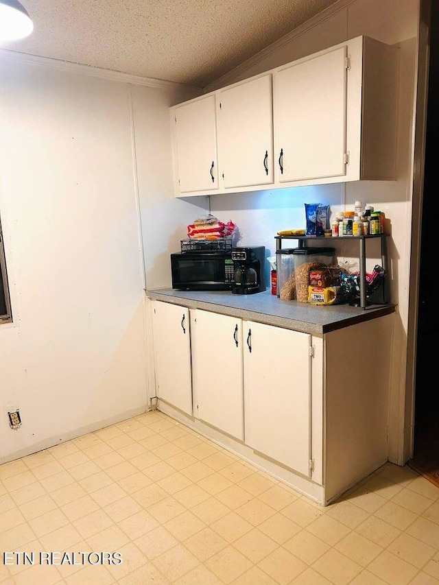 181 Claude Hargis Ln, Crawford, TN 38554 - kitchen with black microwave, white cabinetry, and a textured ceiling
