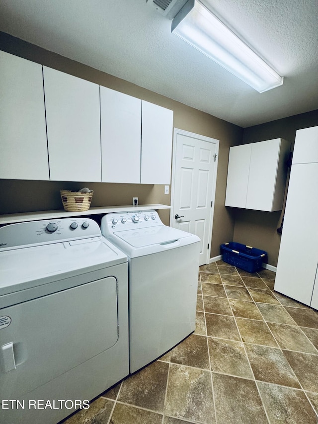 13001 Sanderling Ln, Knoxville, TN 37922 - laundry room featuring cabinet space, independent washer and dryer, a textured ceiling, and dark stone finish flooring
