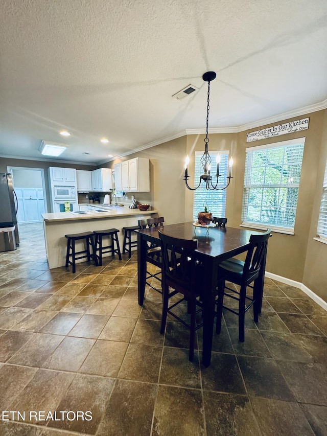 13001 Sanderling Ln, Knoxville, TN 37922 - dining room with crown molding, stone tile flooring, a chandelier, a textured ceiling, and recessed lighting