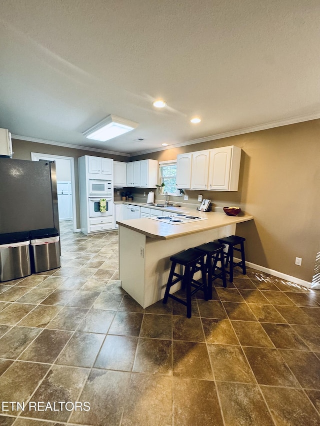13001 Sanderling Ln, Knoxville, TN 37922 - kitchen with crown molding, a peninsula, white appliances, white cabinets, and recessed lighting