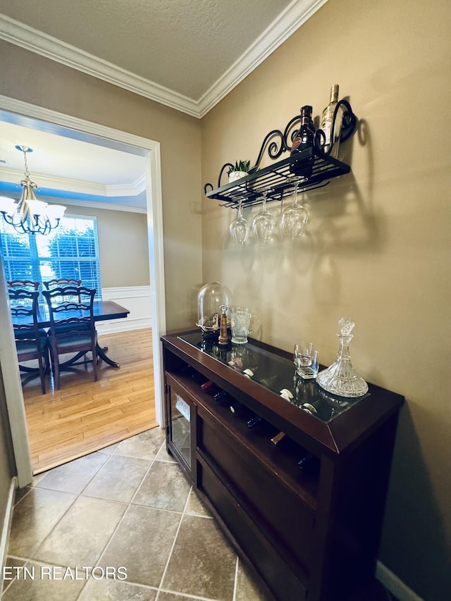 13001 Sanderling Ln, Knoxville, TN 37922 - indoor dry bar with crown molding, a chandelier, light tile patterned flooring, wainscoting, and a textured ceiling