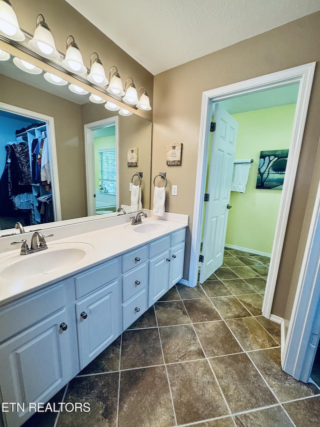 13001 Sanderling Ln, Knoxville, TN 37922 - bathroom featuring double vanity, a spacious closet, and a textured ceiling
