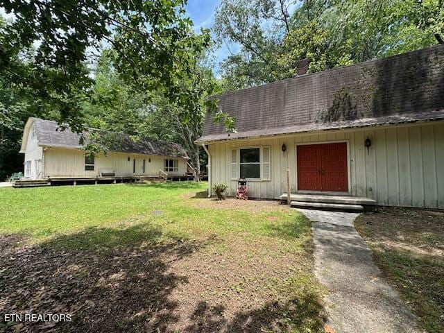 259 Watson Ln, Middlesboro, KY 40965 - view of front of property with a front yard, board and batten siding, a chimney, and a shingled roof
