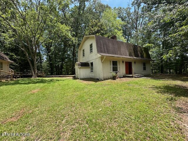 259 Watson Ln, Middlesboro, KY 40965 - view of front of house featuring a gambrel roof, a chimney, a front lawn, and a shingled roof