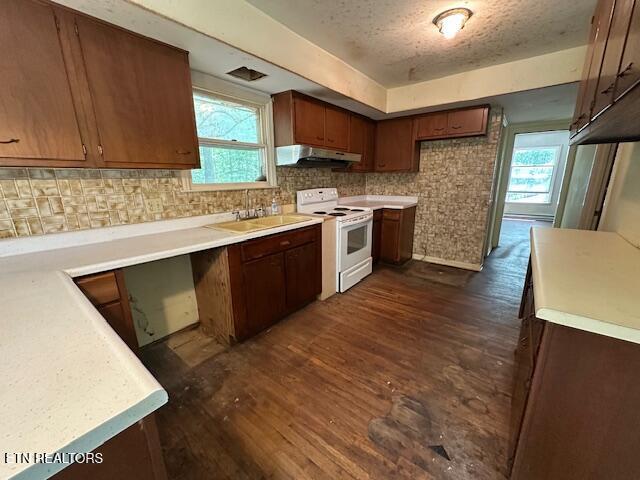 259 Watson Ln, Middlesboro, KY 40965 - kitchen with white range with electric cooktop, under cabinet range hood, dark wood finished floors, decorative backsplash, and a textured ceiling