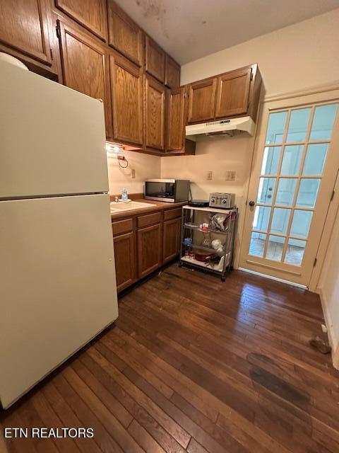 259 Watson Ln, Middlesboro, KY 40965 - kitchen featuring freestanding refrigerator, under cabinet range hood, dark wood-style flooring, and stainless steel microwave