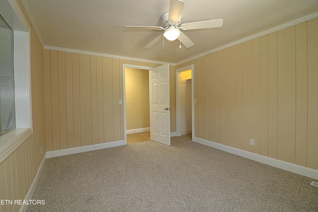 22453 Alberta St, Oneida, TN 37841 - spare room featuring a ceiling fan, carpet, crown molding, and wooden walls