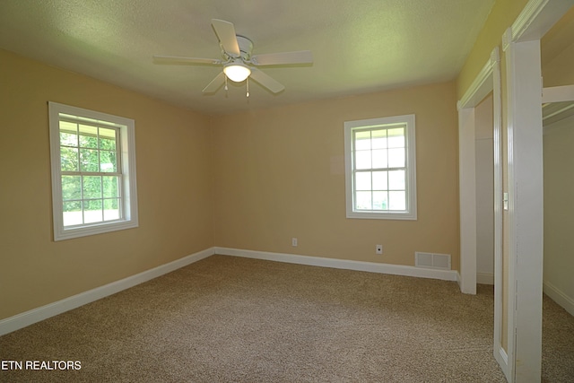 22453 Alberta St, Oneida, TN 37841 - unfurnished bedroom with multiple windows, carpet, a textured ceiling, and a ceiling fan