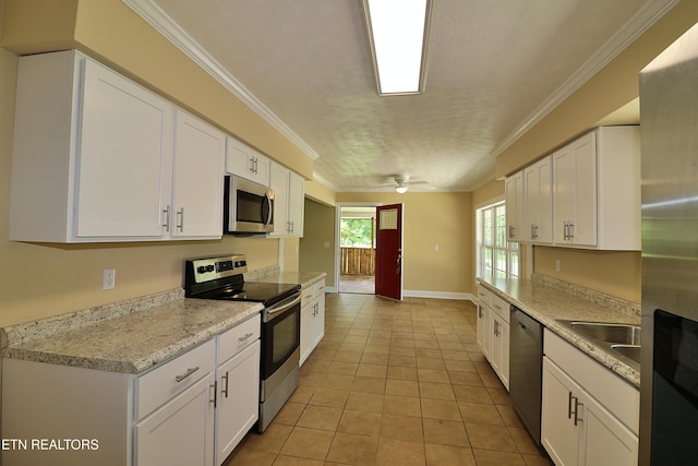 22453 Alberta St, Oneida, TN 37841 - kitchen featuring stainless steel appliances, white cabinetry, light countertops, ornamental molding, and light tile patterned floors