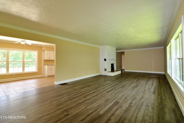 22453 Alberta St, Oneida, TN 37841 - unfurnished living room with a textured ceiling, dark wood-style flooring, crown molding, a fireplace, and plenty of natural light