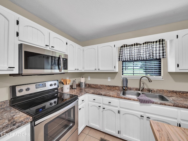 1371 Elijah Martin Rd, Whitesburg, TN 37891 - kitchen featuring stainless steel appliances, dark countertops, white cabinetry, and light tile patterned floors