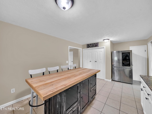 1371 Elijah Martin Rd, Whitesburg, TN 37891 - kitchen with smart refrigerator, light tile patterned floors, a breakfast bar, dark cabinets, and a textured ceiling