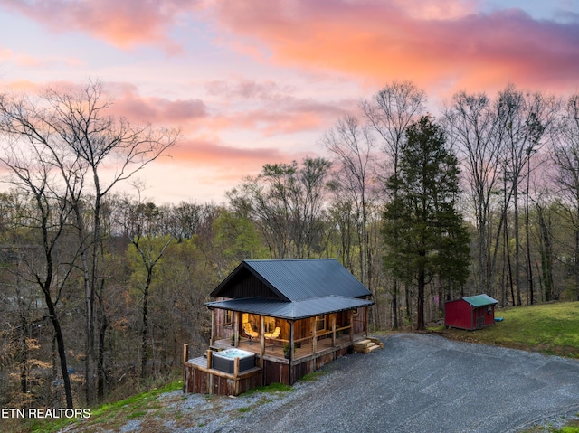 1023 Timberlake Cir, Sevierville, TN 37876 - view of front of house with covered porch, a metal roof, a storage unit, and a view of trees