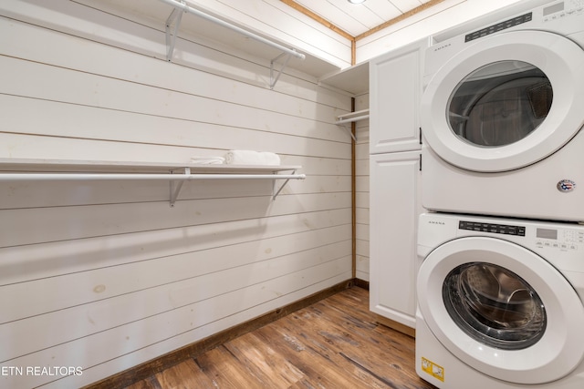 1023 Timberlake Cir, Sevierville, TN 37876 - laundry room featuring stacked washer / dryer, wooden walls, wood finished floors, and cabinet space