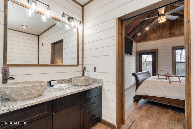 1023 Timberlake Cir, Sevierville, TN 37876 - ensuite bathroom featuring wood walls, vanity, vaulted ceiling, ceiling fan, and wood finished floors