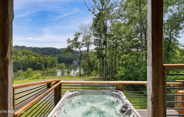 1023 Timberlake Cir, Sevierville, TN 37876 - deck featuring an outdoor hot tub, a water view, and a forest view