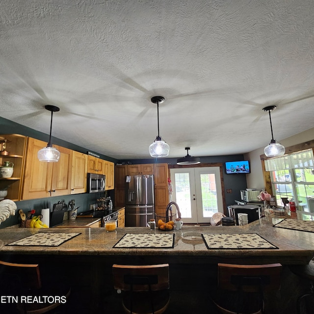 1100 Mill Branch Rd, Huntsville, TN 37756 - kitchen featuring appliances with stainless steel finishes, a peninsula, a kitchen bar, a textured ceiling, and french doors
