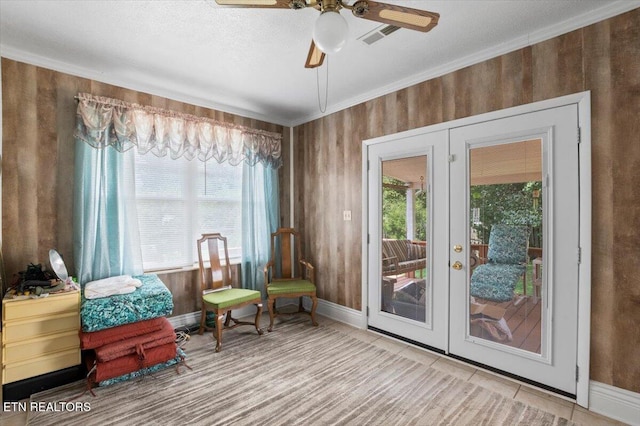 116 Oak St, Jacksboro, TN 37757 - living area featuring french doors, a ceiling fan, healthy amount of natural light, ornamental molding, and wooden walls