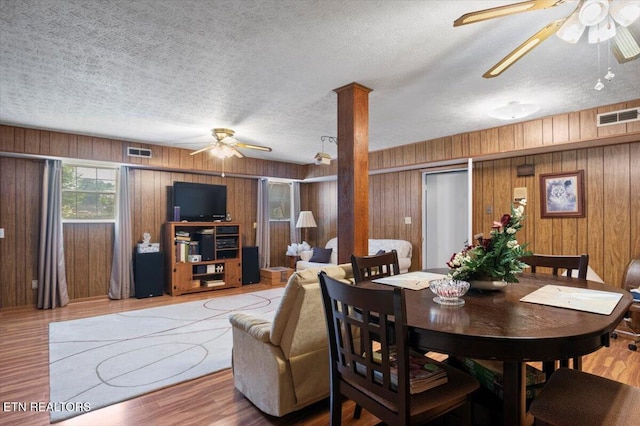 116 Oak St, Jacksboro, TN 37757 - dining room with a ceiling fan, wooden walls, a textured ceiling, wood finished floors, and ornate columns