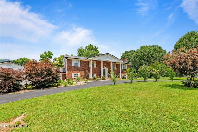 116 Oak St, Jacksboro, TN 37757 - view of front of home featuring a front yard, driveway, brick siding, and a chimney