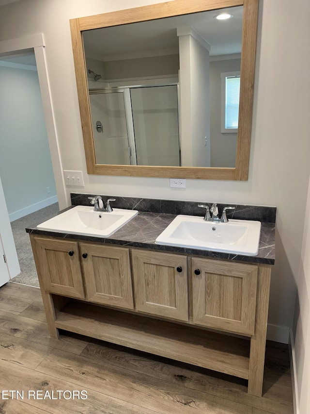 9556 Crisman Rd, Heiskell, TN 37754 - full bathroom with double vanity, ornamental molding, a shower stall, and wood finished floors