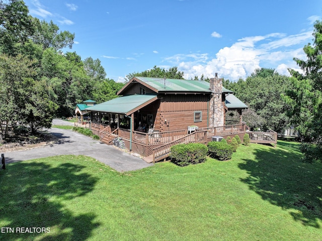 721 Leisure Way, Newport, TN 37821 - view of side of property with a chimney, a lawn, a deck, and a metal roof