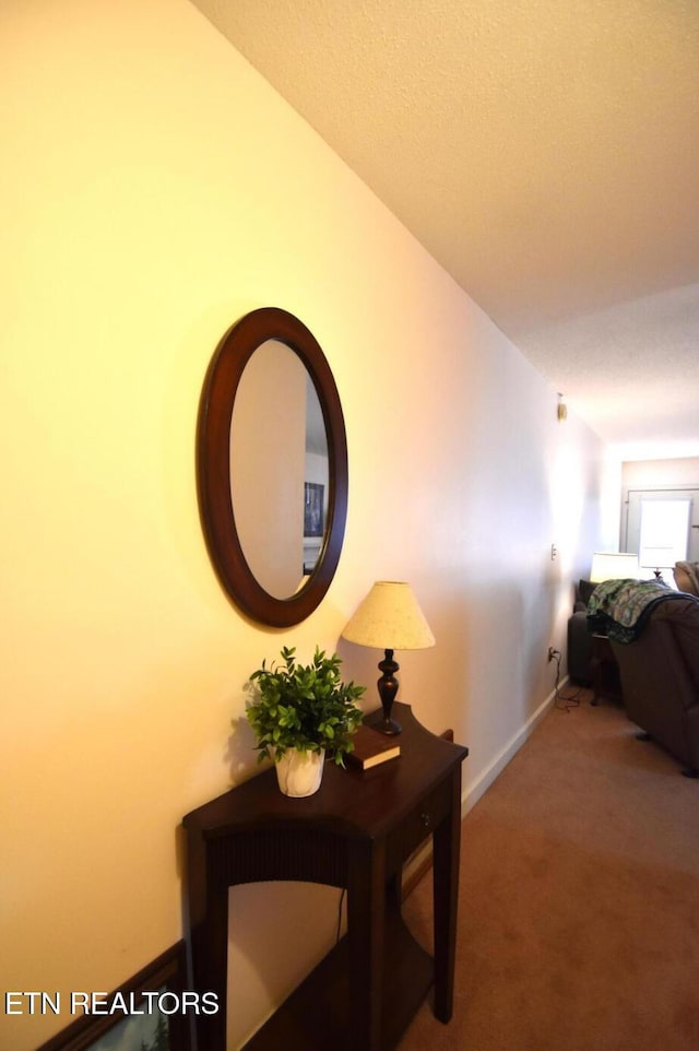 hallway with carpet flooring and baseboards