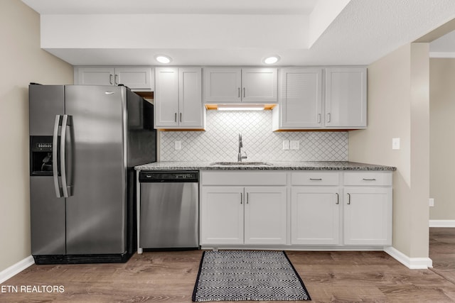 8707 Olde Colony Trl Unit 13, Knoxville, TN 37923 - kitchen featuring appliances with stainless steel finishes, light stone countertops, tasteful backsplash, and light wood-style floors