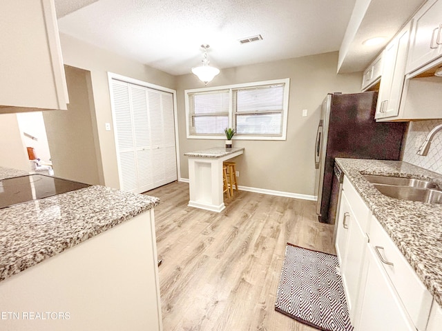 8707 Olde Colony Trl Unit 13, Knoxville, TN 37923 - kitchen with light wood-style floors, white cabinets, tasteful backsplash, and light stone counters