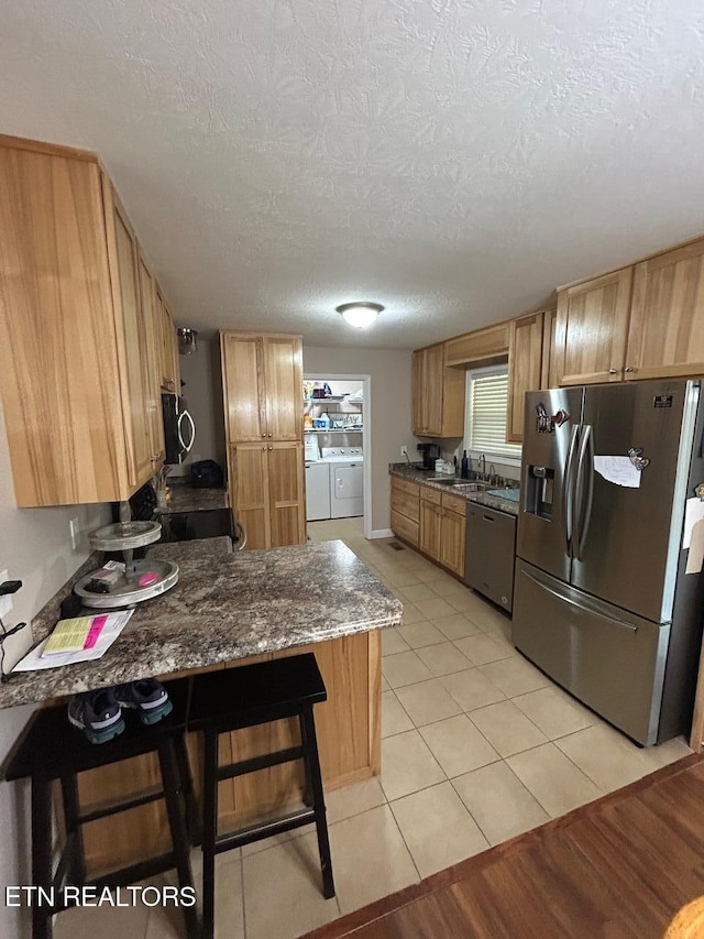 935 Pinetree Rd, Jamestown, TN 38556 - kitchen featuring stainless steel appliances, independent washer and dryer, a textured ceiling, a peninsula, and dark stone countertops